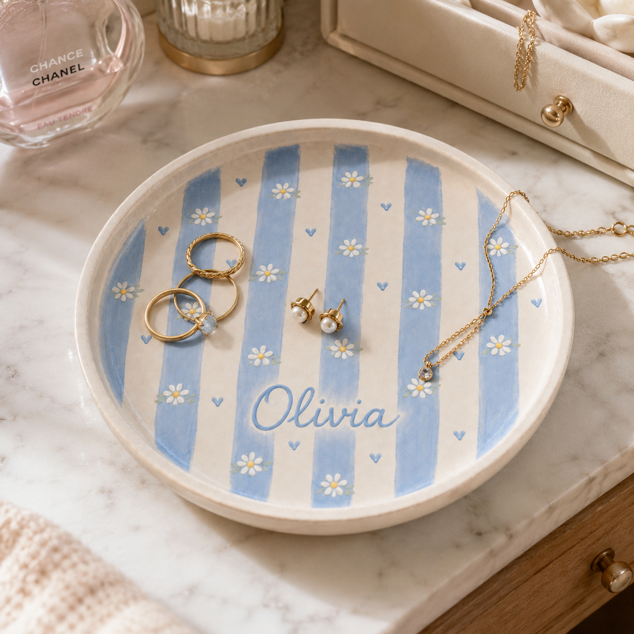 Personalized blue daisy ceramic trinket dish styled with rings and Olivia name