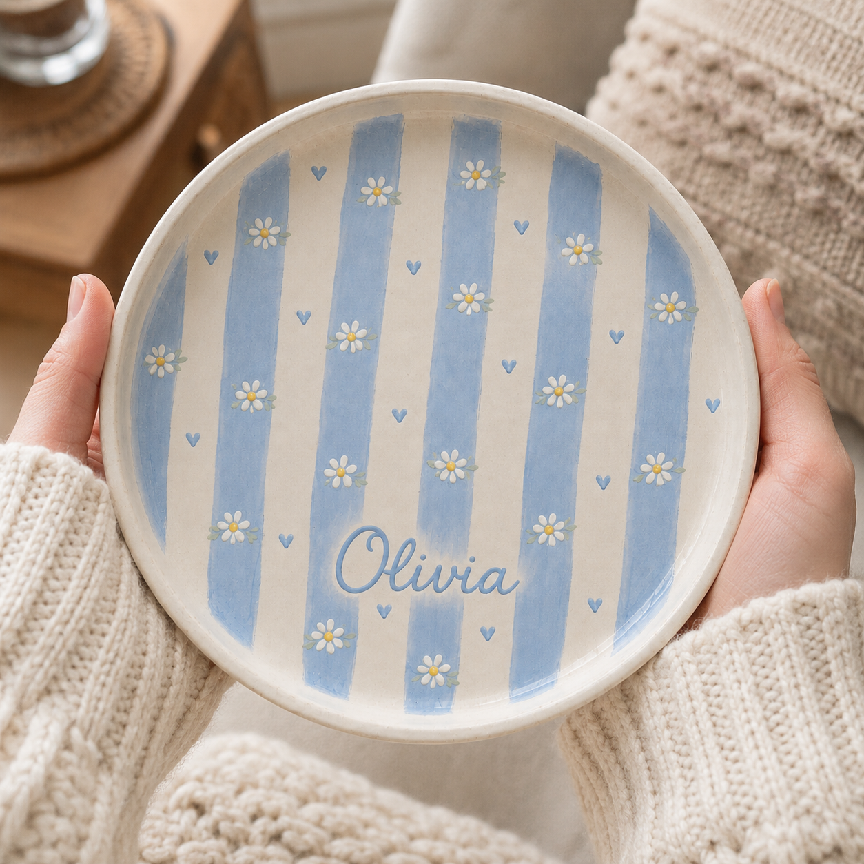 Blue personalized daisy ceramic trinket dish held in hands with Olivia name