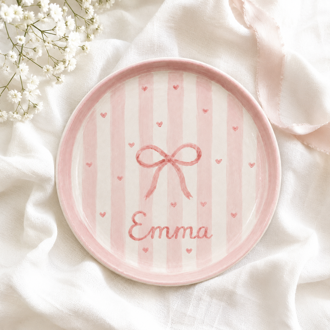 Pink striped ceramic trinket dish with bow and Emma name on soft fabric