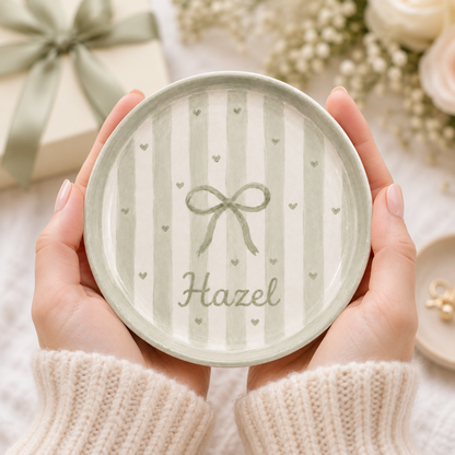 Sage green bow personalized ceramic trinket dish held in hands with Hazel name
