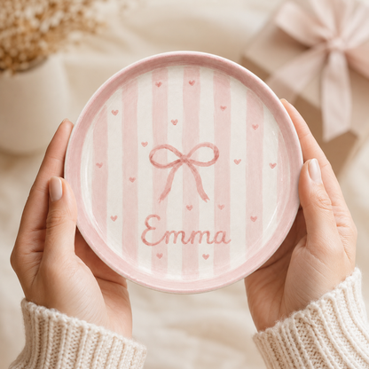 Pink bow personalized ceramic trinket dish held in hands with Emma name