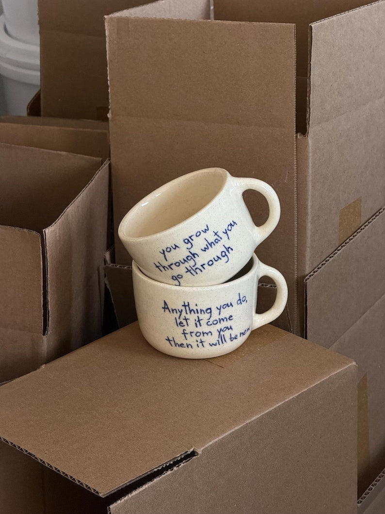 Stacked personalized ceramic mugs on cardboard boxes