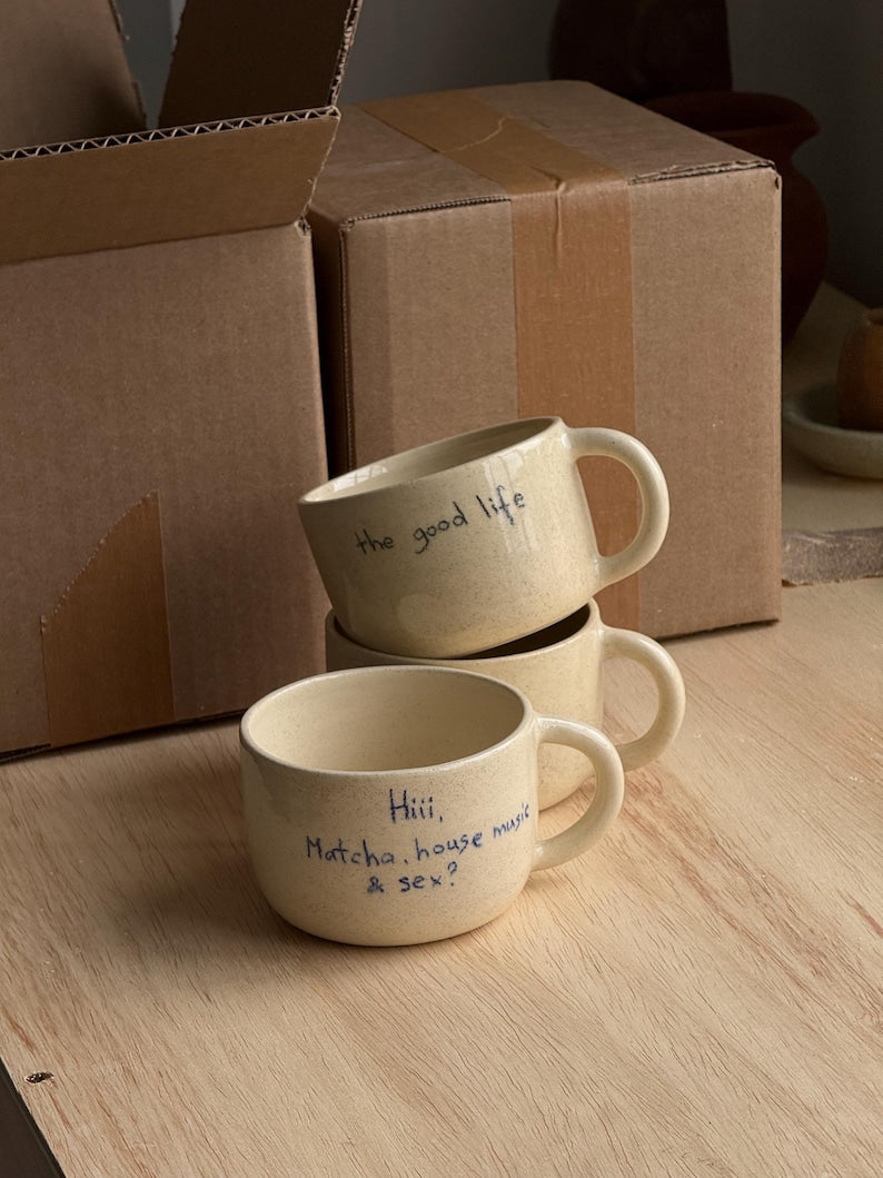 Stack of personalized ceramic mugs in studio setting